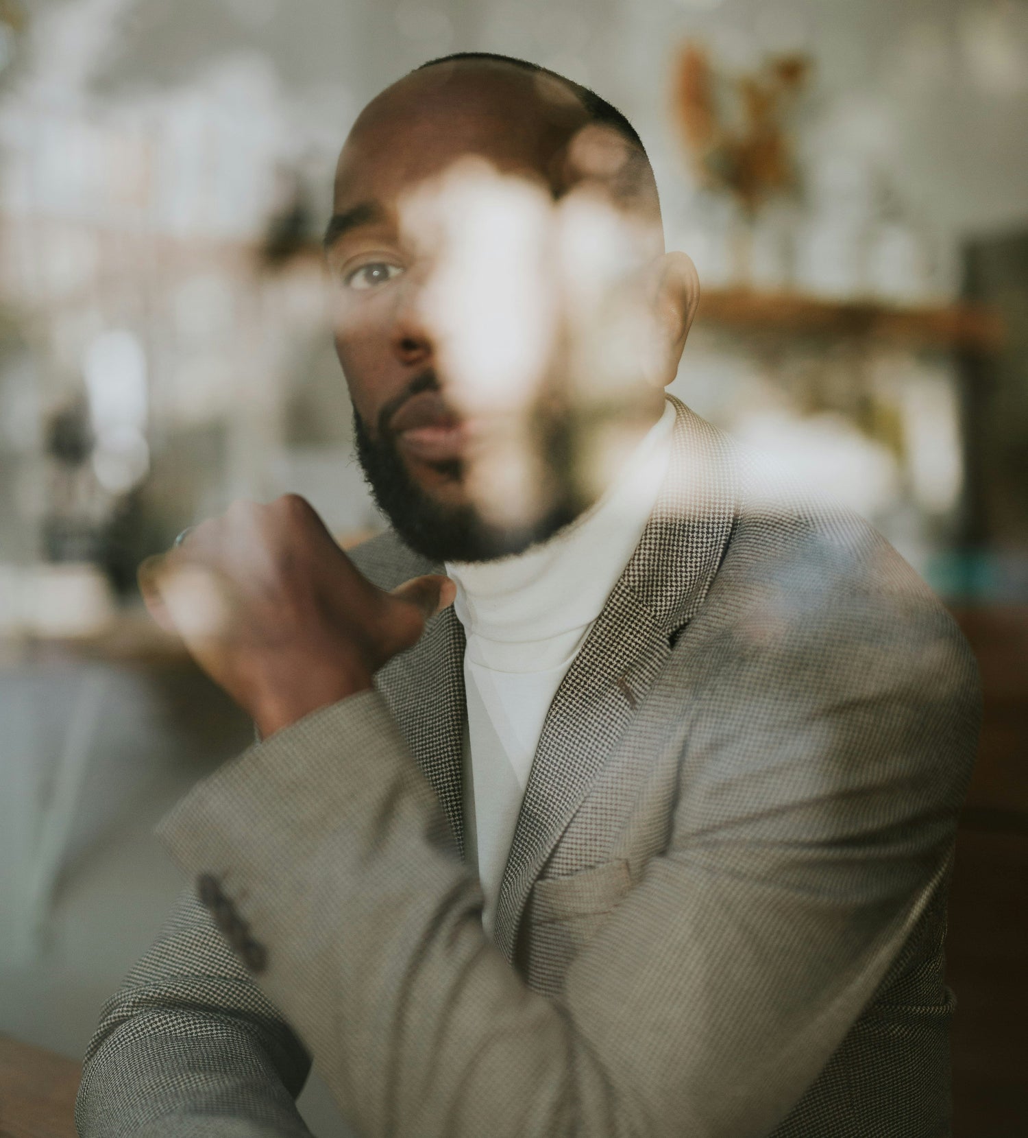 Man in a suit sitting at a table with a blurred background